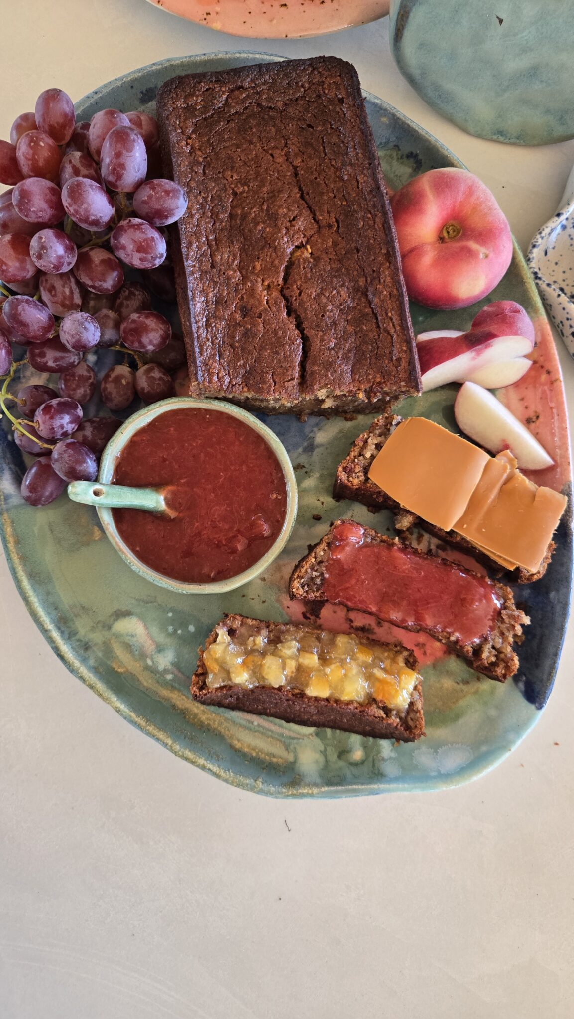 Saftig bananbrød med havremel, servert i skiver med brunost, syltetøy og marmelade